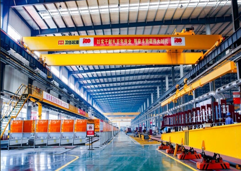 An overhead crane used for lifting and moving materials across a wider workshop area.